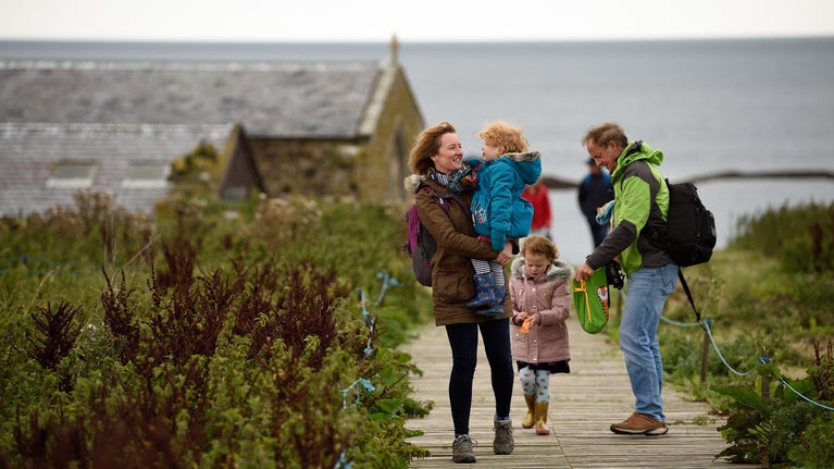 A family on a walk in autumn around Inner Farne at the Farne Islands, Northumberland